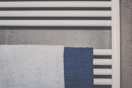Towels heat up on a modern radiator in the bathroom. Closeup view of a towelの写真素材