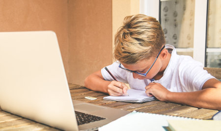 Student doing homework. Boy writing, drawing sitting at the table. School, youth, education concept.の写真素材