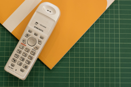 Work space telephone and yellow card green background.の写真素材