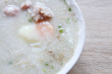 Pork chops rice porridge or congee with boiled egg, favorite breakfast in Thailand, close-up viewの写真素材