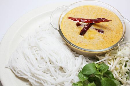 Traditional Thai menu, rice noodles in fish curry sauce with vegetables (called Kanom Jeen Nam Ya in Thai) isolated on white backgroundの写真素材