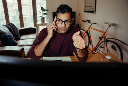 Mixed race business man chatting to colleague explaining concepts while working from home officeの写真素材