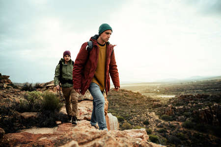 Caucasian group of friends hiking on mountain top exercising enjoying the outdoorsの写真素材