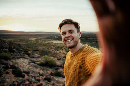 Caucasian male free spirit hiking in wilderness taking selfies with cellular device
