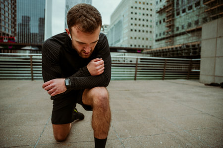 Caucasian male athlete taking a break kneeling down after long workout