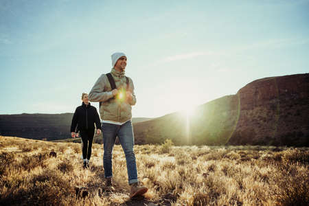 Young teens hiking in luscious mountain terrain during sunset