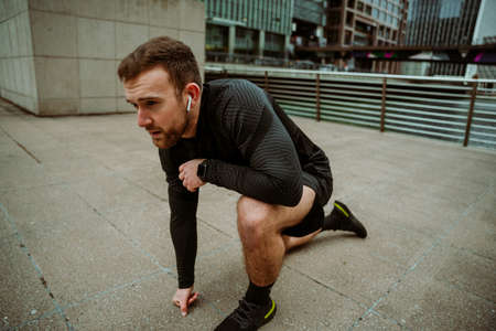 Caucasian male athlete preparing to run kneeling on ground