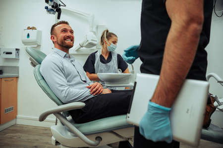Smiling caucasian male client happy after successful teeth cleaningの写真素材