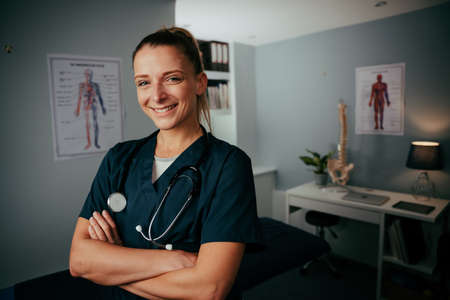 Caucasian female nurse standing in clinic with with crossed armsの写真素材