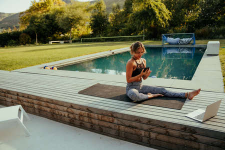 Caucasian female teen typing on cellular device working out at homeの写真素材