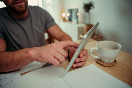 Close up caucasian couple working from home typing on digital tabletの写真素材