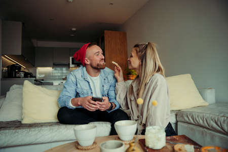 Caucasian couple being playful feeding each other breakfast
