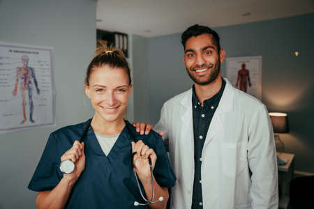 Caucasian female nurse standing with mixed race male surgeonの写真素材