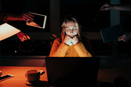 Caucasian female tired student working on. team project sitting at laptop late at night falling asleep in handsの写真素材