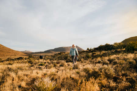 Free-spirited teen exploring through fields during sunsetの写真素材