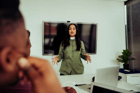 Business woman using hand gestures while presenting ideas to clients presenting in board room