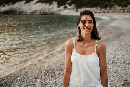 Caucasian female walking along the beach smilingの写真素材