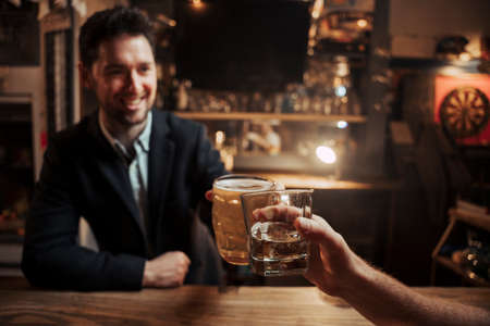 Caucasian customer sitting at bar having a drink with bartenderの写真素材