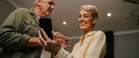 Caucasian senior couple texting on cellular device
