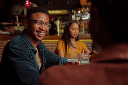 African american male smiling while enjoying time with friends in restaurant