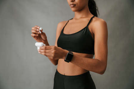 African American female putting ear pods back into containerの写真素材