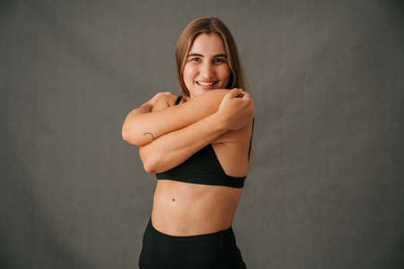 Fun loving Caucasian female giving herself a hugの写真素材