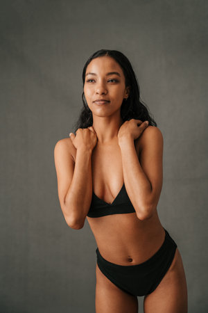 Multiethnic female standing with her hands on her shouldersの写真素材