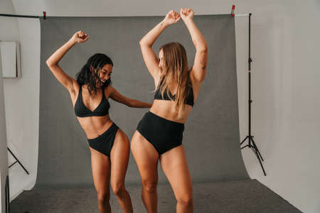 Two females with different shaped bodies dancing and having funの写真素材