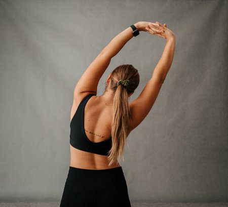 Young fit woman doing a waist stretching exerciseの写真素材