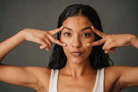 Multiethnic female making peace symbol with both handsの写真素材