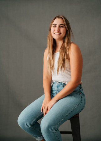 Close up Lovely blond female smiling and sitting on a high chairの写真素材