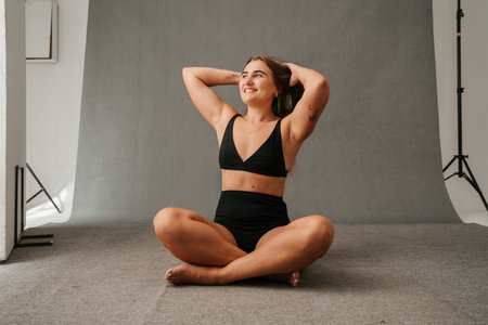 Excited and happy female sitting on the floor in the studio