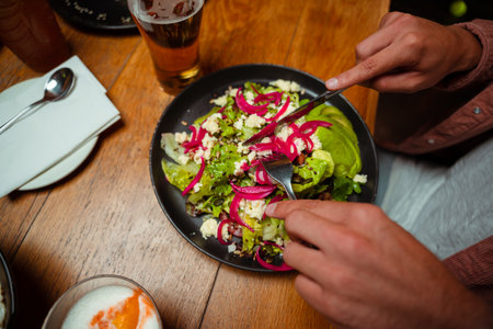 Friends eating delicious healthy meal at restaurantの写真素材