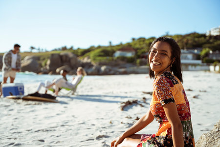 Smiling Woman sitting on the beach in the Sunの写真素材