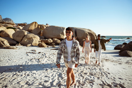 A Man Walking On The Beach His Friends Behind Himの写真素材