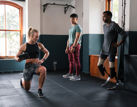 Group in gym doing leg exercises in shorts by windowの写真素材