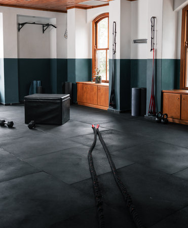 Gym with black hardwood floor and dual ropes for workoutsの写真素材