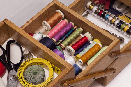A sewing box with colorful threads and tools.