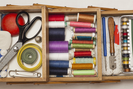 A sewing box with colorful threads and tools.の写真素材