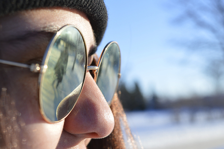 Reflection of a woman in a ladies glasses on a cold Winter day.の写真素材