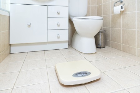 Photo of the bathroom floor with weight scale in the foregroundの写真素材