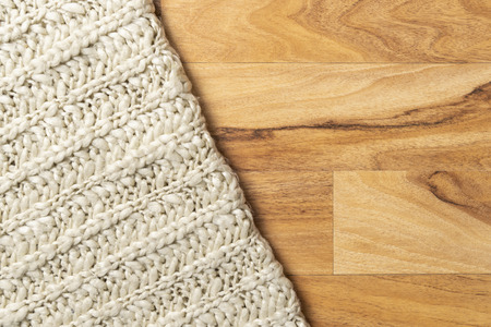 Wool blanket, white, knitted large chunky yarn. Close-up of knitted blanket on wooden background.の写真素材