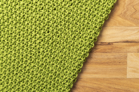 Wool blanket, green, knitted large chunky yarn. Close-up of knitted blanket on wooden background.の写真素材
