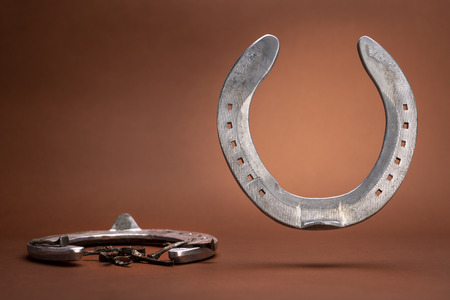 Levitating horseshoe and nails isolated on a brown background with copy spaceの写真素材