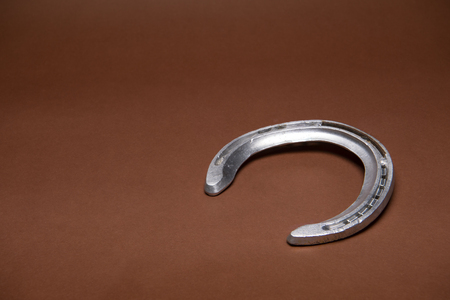 Single horseshoe isolated on a brown background with copy spaceの写真素材