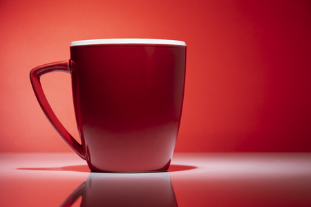 Red tea or coffee mug isolated on the red backgroundの写真素材