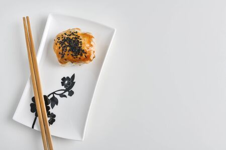 Chinese red bean paste cakes and chopsticks on ceramic plate, isolated on white backgroundの写真素材