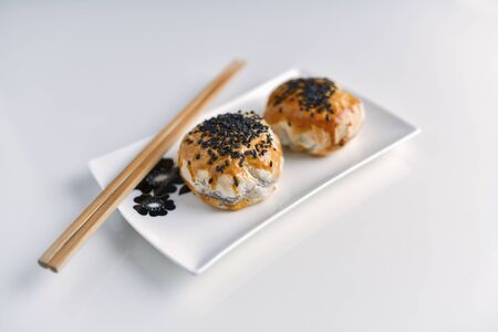 Chinese red bean paste cakes and chopsticks on ceramic plate, isolated on white backgroundの写真素材