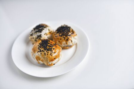 Chinese red bean paste cakes on ceramic plate, isolated on white backgroundの写真素材