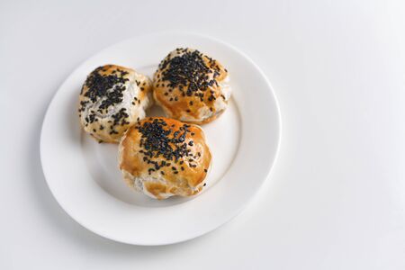 Chinese red bean paste cakes on ceramic plate, isolated on white backgroundの写真素材